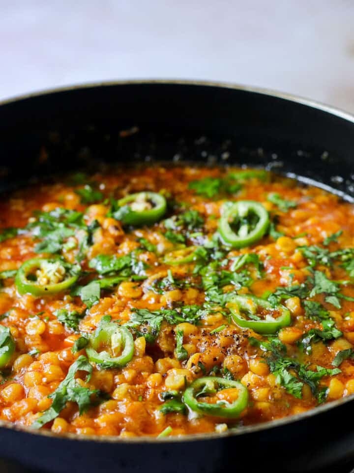 dhaba style chana dal in a wok garnished with green chilies and coriander