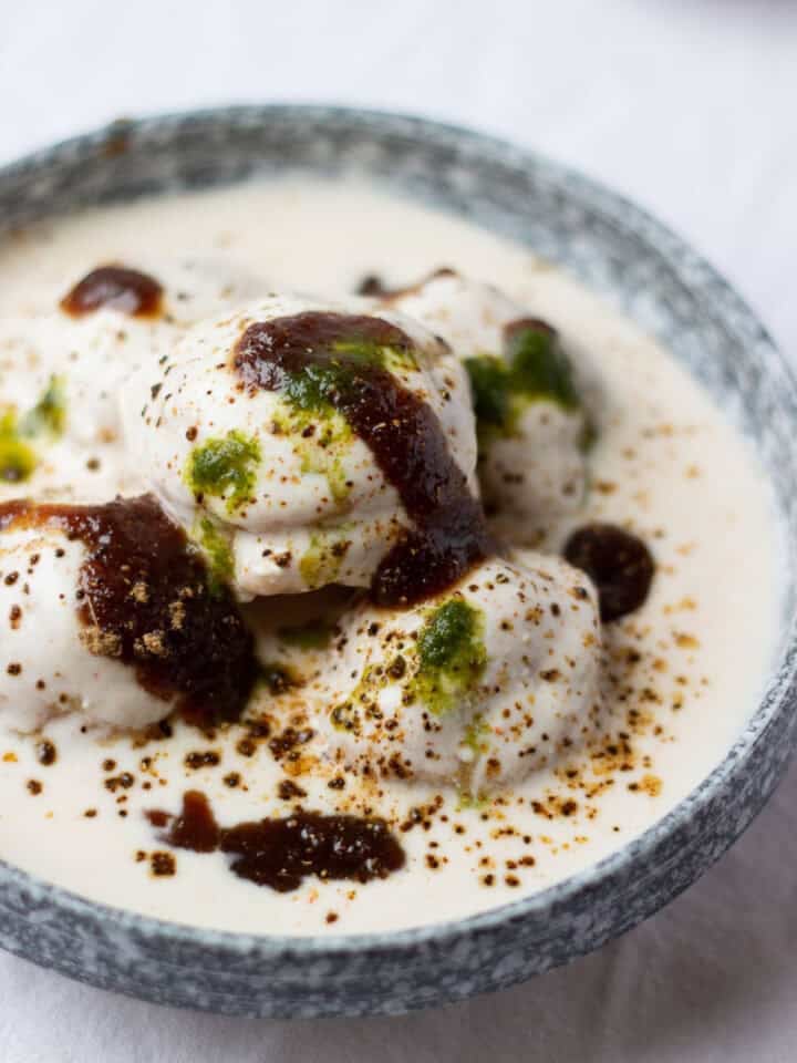 Dahi baray in a bowl drizzled with tamarind chutney and chaat masala