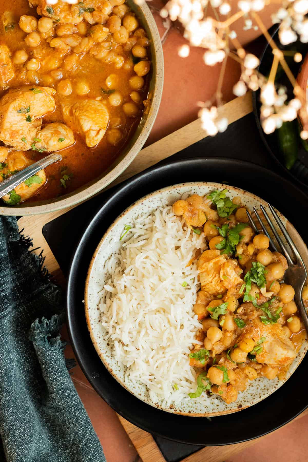 top down view of a dish of murgh cholay and a plate of rice and murgh cholay