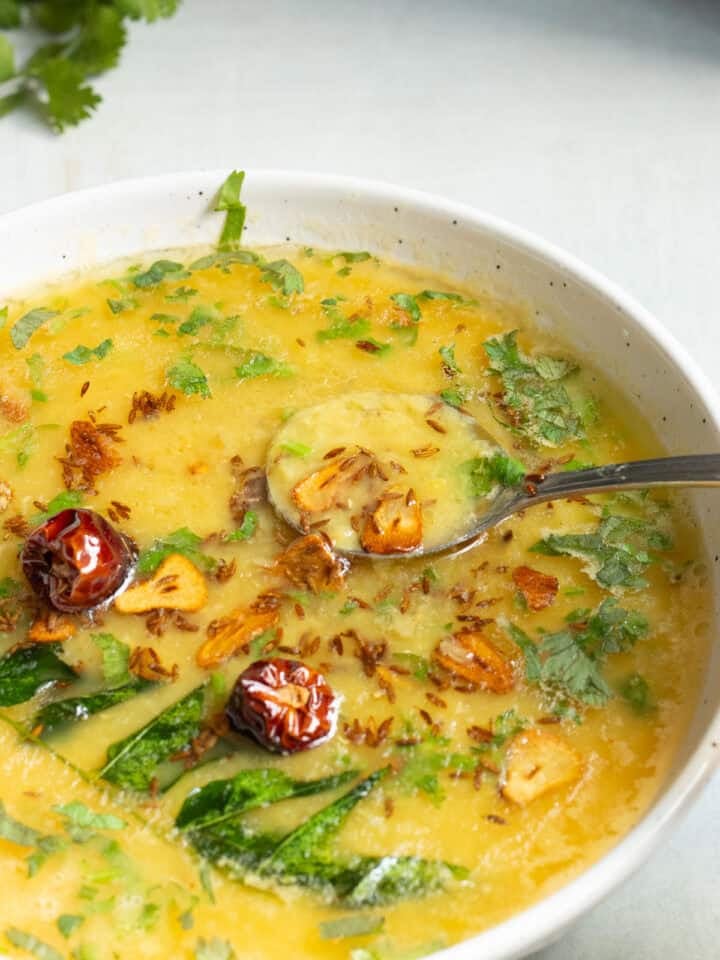 a dish of masoor ki daal with a spoon in it