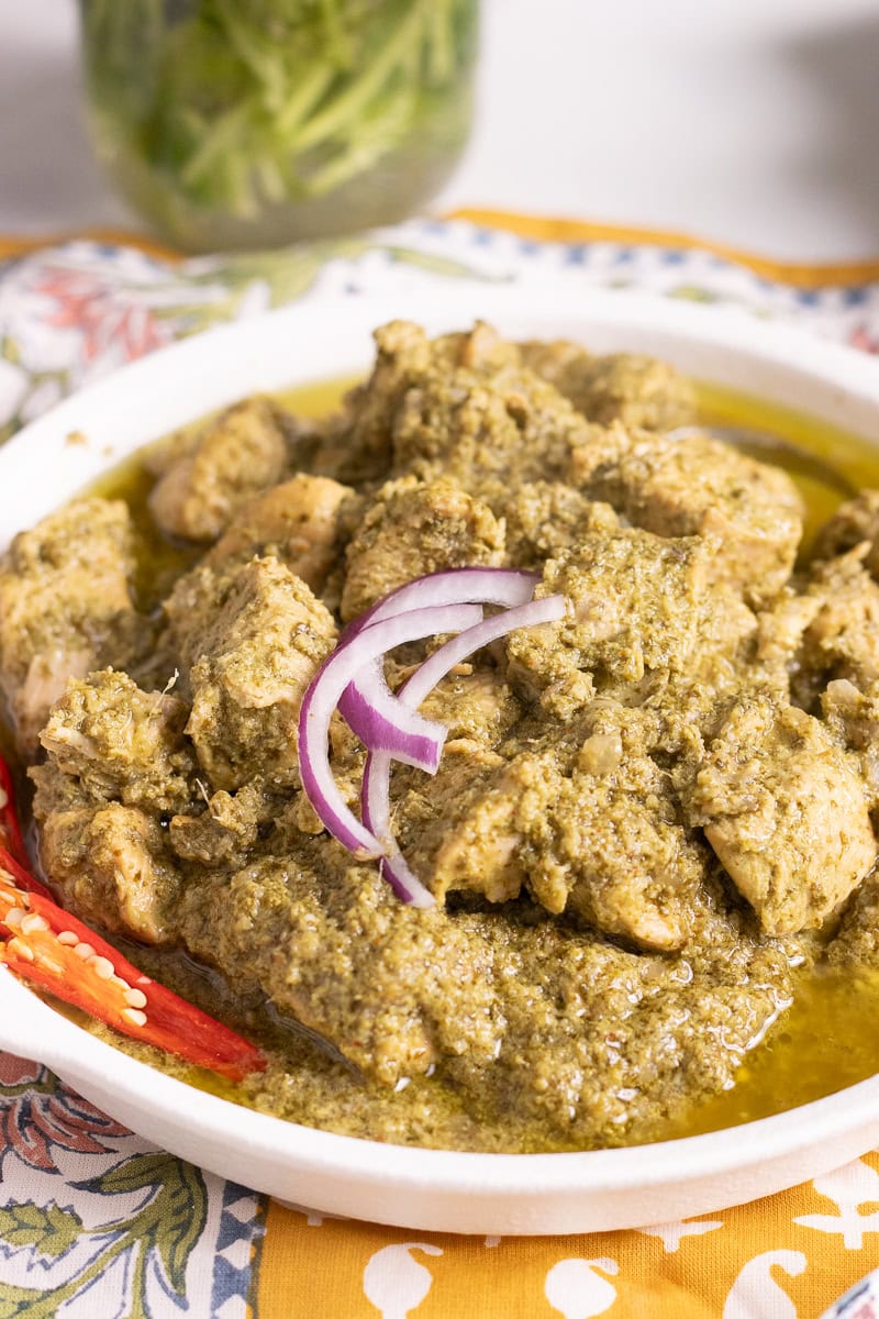 Hara Masala Chicken in a dish with onions and a sliced chili