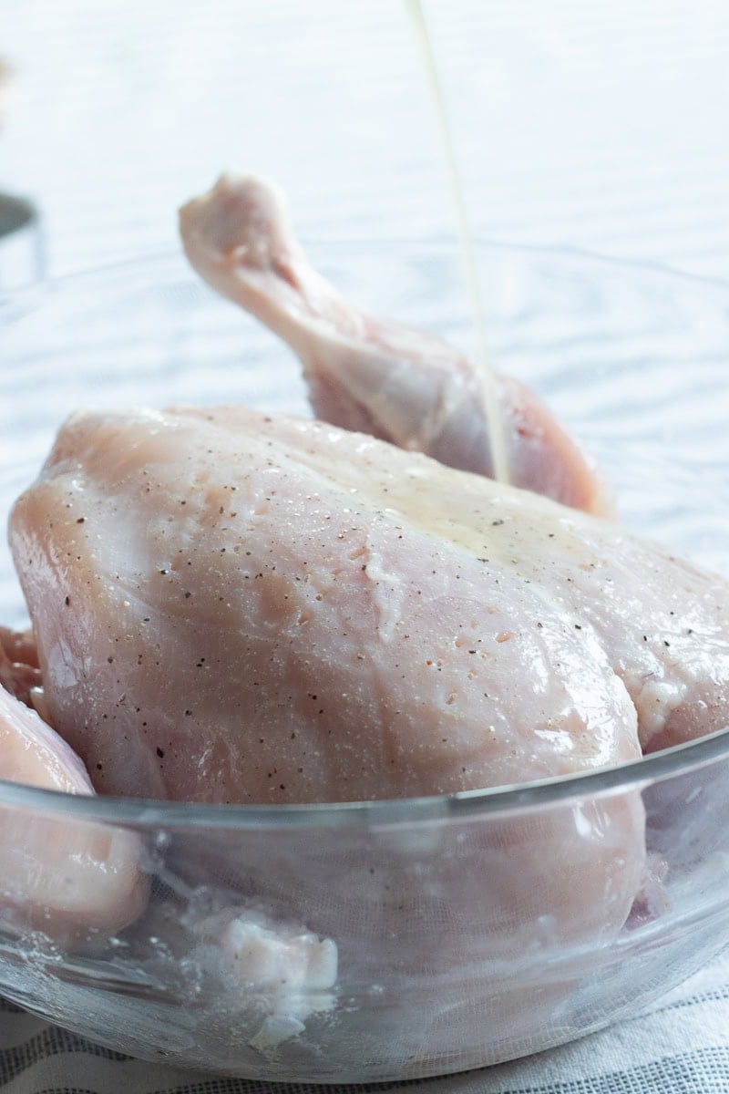 marinade for the roast being poured onto a chicken 