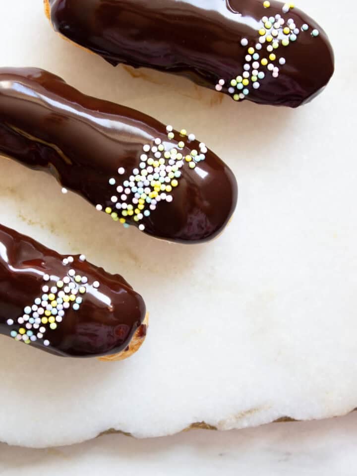 Three eclairs on a marble surface
