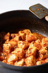 chicken coated in a spices in a black braiser