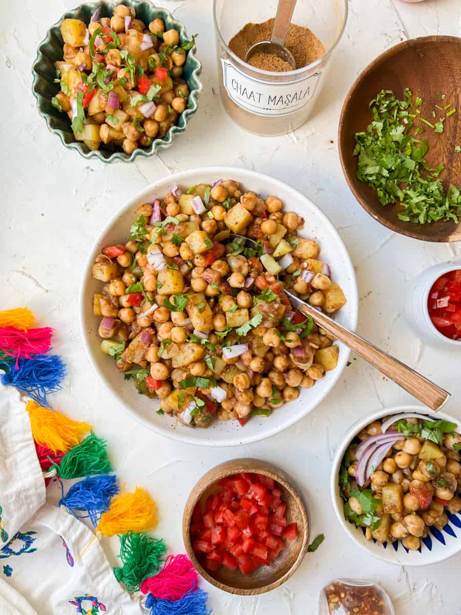 Top down view of bowls of chaat with extra toppings in smaller bowls