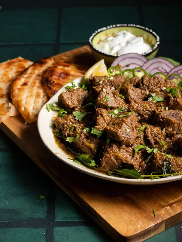 Tala hua Gosht in a plate, sheermal on a board with it