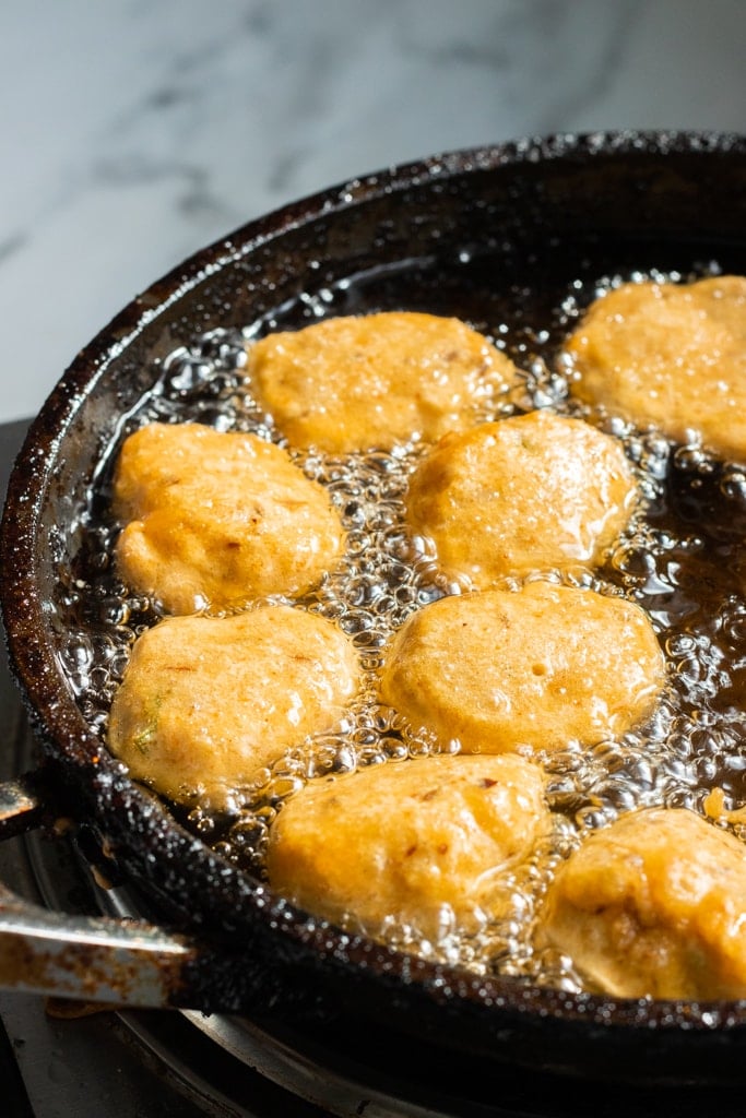 pakoras in oil in a frying pan