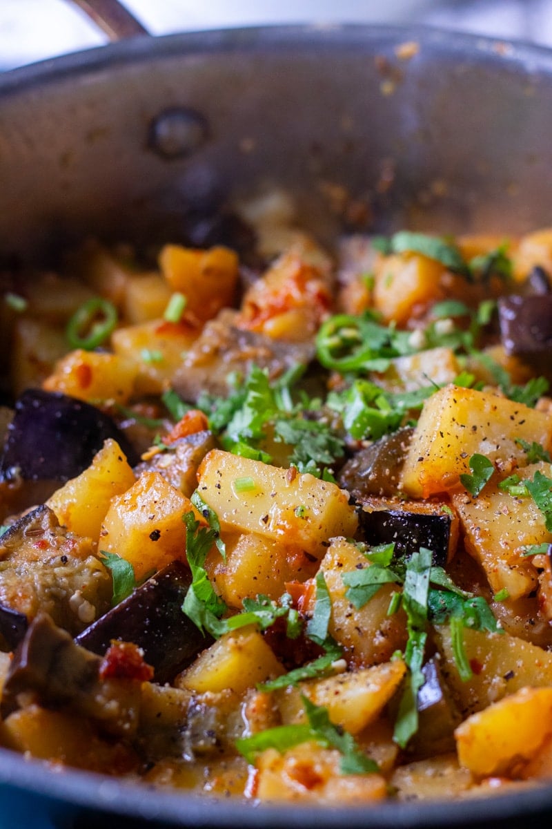 Aloo baingan garnished with cilantro and green chilies