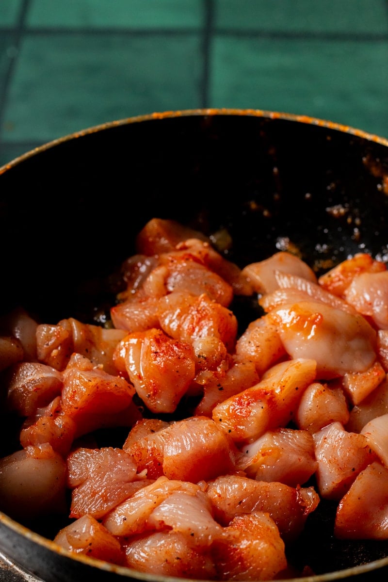 spice rubbed chicken being cooked in a pan