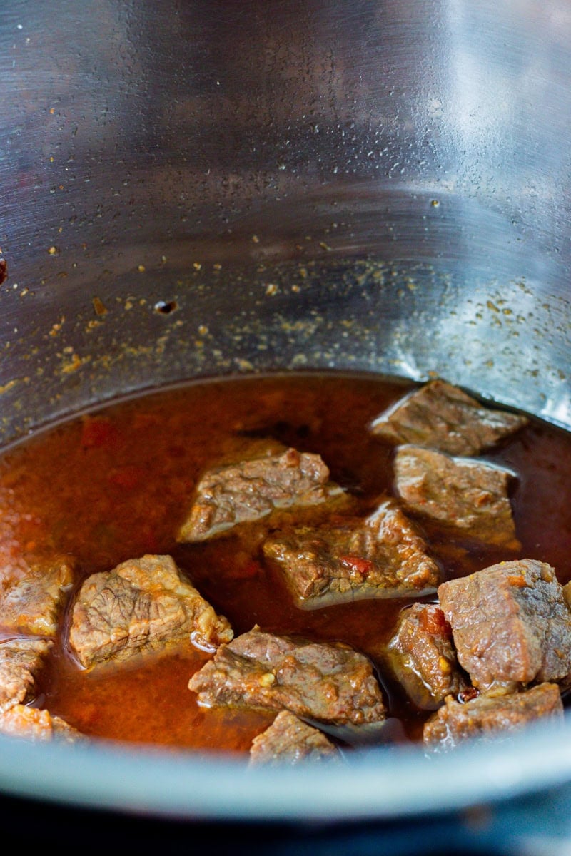 semi cooked meat cubes in a gravy in the instant pot