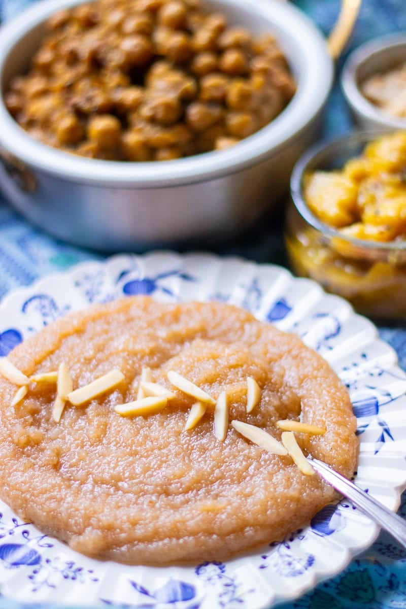 sooji ka halwa in a plate with chana and aloo in the background